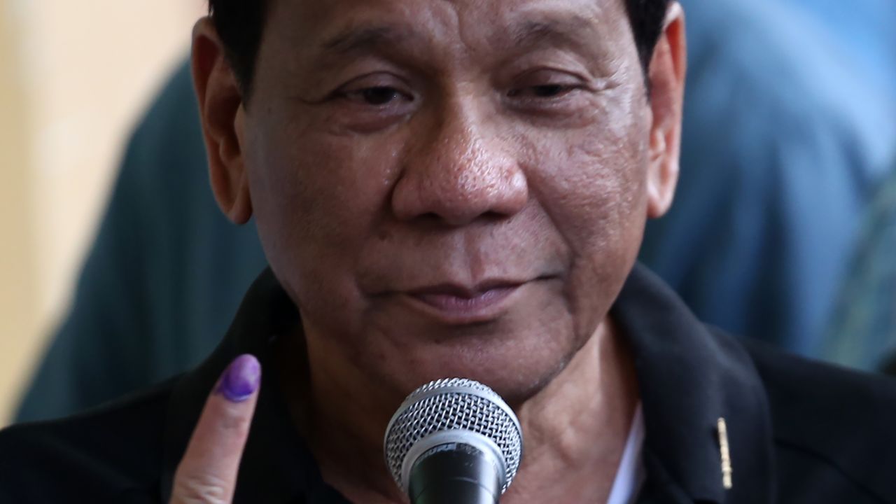 Philippines President Rodrigo Duterte shows the ink on his finger after voting in his hometown of Davao City, where three of his children were on the ballot.
