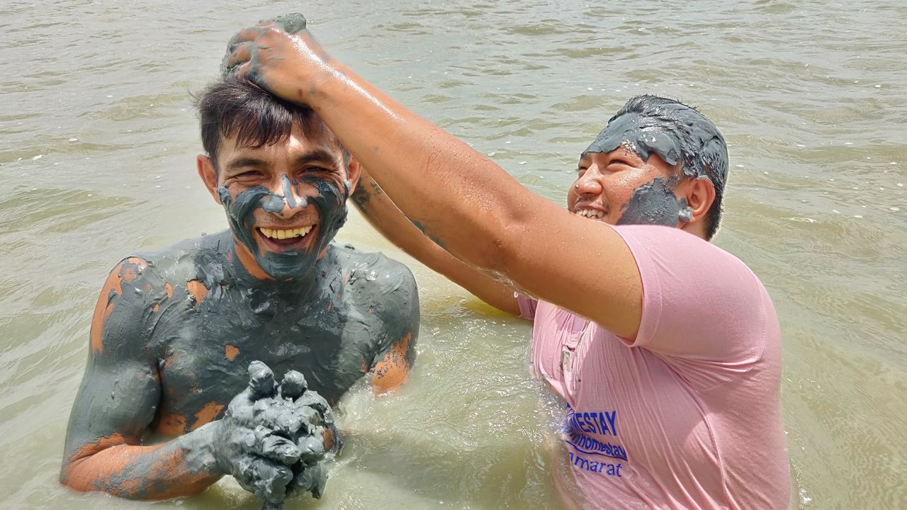 Thaksin Minman (left) and Fud Himma (right) demonstrate the mud beauty treatment.