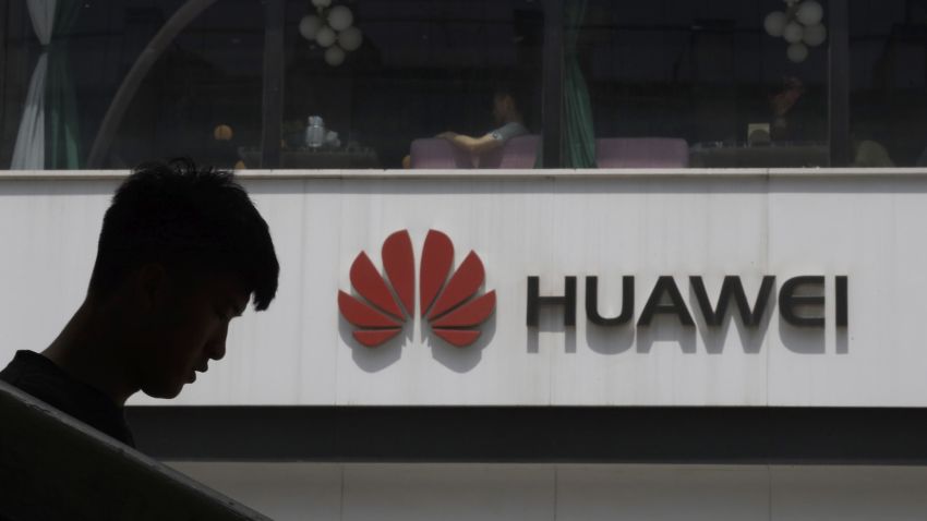 A Chinese man is silhouetted near the Huawei logo in Beijing on Thursday, May 16, 2019. In a fateful swipe at telecommunications giant Huawei, the Trump administration issued an executive order Wednesday apparently aimed at banning its equipment from U.S. networks and said it was subjecting the Chinese company to strict export controls. (AP Photo/Ng Han Guan)