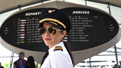 Samantha Gershman dressed as a TWA pilot poses for a picture after the  ribbon cutting ceremony to officially open the TWA Hotel at JFK International Airport in New York May 15, 2019. - The  former 1962 TWA Flight Center designed by the architect Eero Saarinen, closed in 2001. The new hotel will  have 512 mid-century-furnished rooms, an infinity pool and lounge on the roof. (Photo by TIMOTHY A. CLARY / AFP)        (Photo credit should read TIMOTHY A. CLARY/AFP/Getty Images)