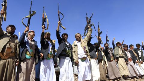 Armed men raise their weapons as they gather near Sanaa to show their support of the Houthi movement in February.