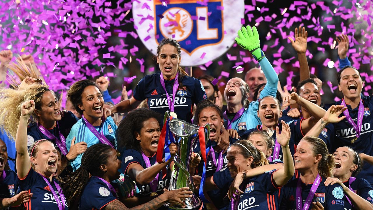 TOPSHOT - Olympique Lyonnais' French defender Wendie Renard (C) holds the trophy with teammates as they celebrate their victory after the UEFA Women's Champions League final football match Vfl Wolfsburg vs Olympique Lyonnais at the Valeriy Lobanovsky stadium in Kiev on May 24, 2018. - Olympique Lyonnais won 4-1, their third trophy in a row. (Photo by FRANCK FIFE / AFP) (Photo credit should read FRANCK FIFE/AFP/Getty Images)