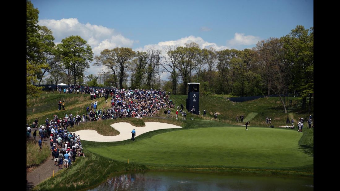 Brooks Koepka putts on a hulking eighth green, watched by fans who were witnessing a clinic from the three-time major winner.