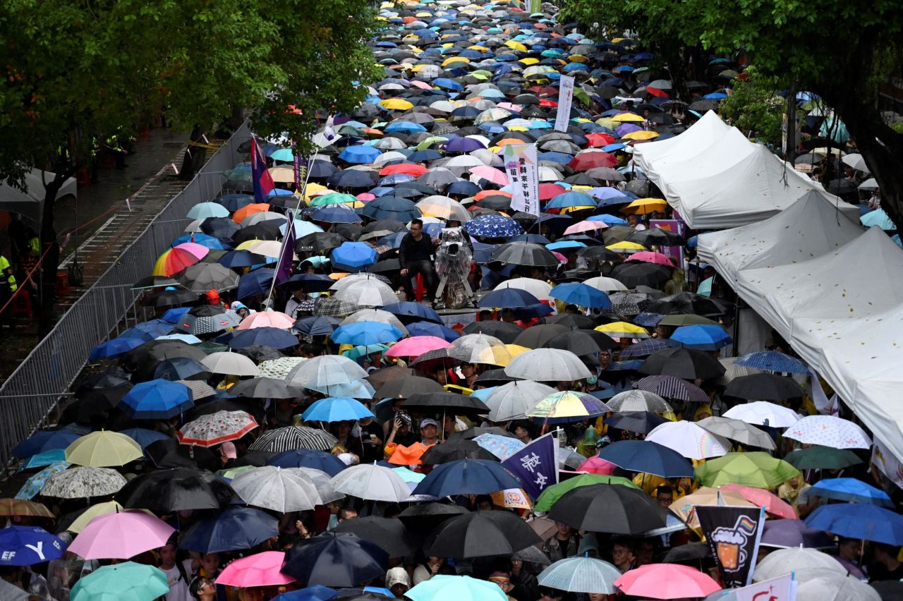 Gay rights supporters wait in the rain outside the parliament building in Taipei before the landmark decision was announced on Friday.