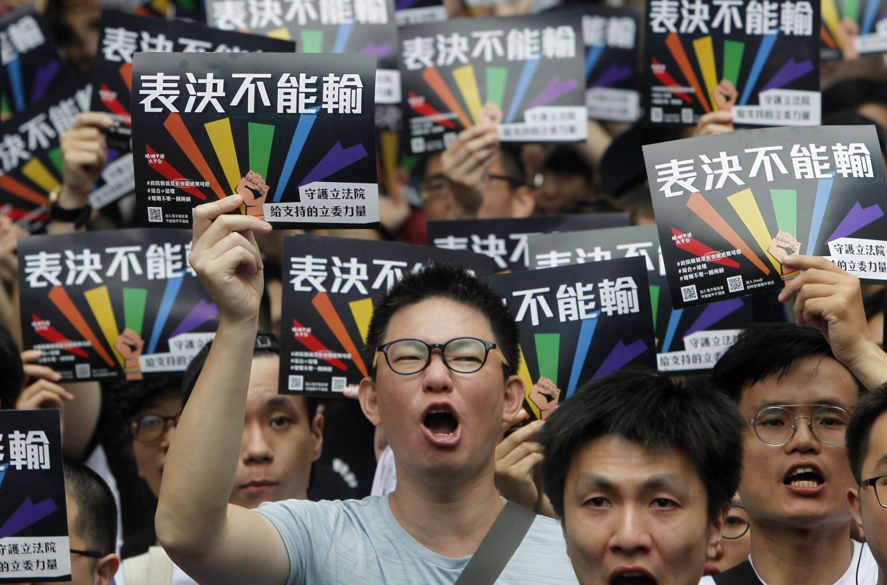 Same-sex marriage supporters gather outside the Legislative Yuan in Taipei, Taiwan. The signs read, ''Vote Can't Be Defeated.''