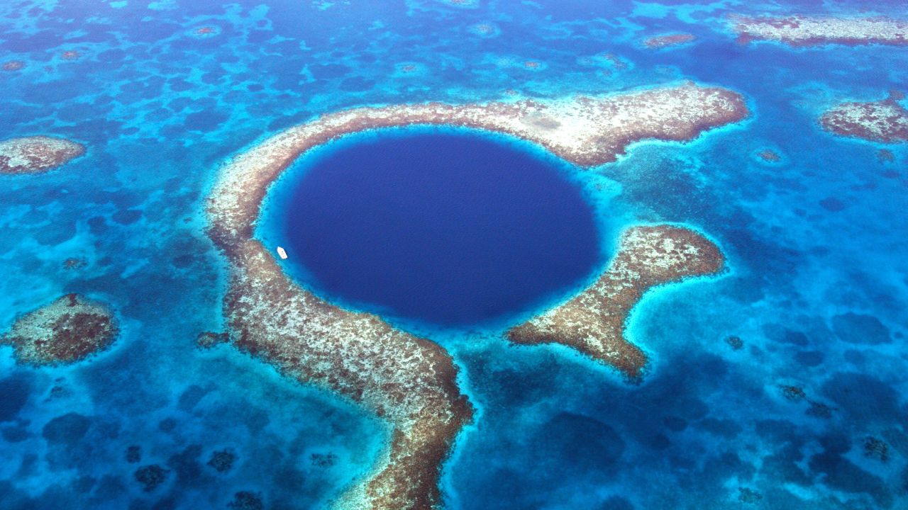 <strong>Great Blue Hole, Belize: </strong>Measuring 300 meters wide and around 125 meters deep, this huge underwater sinkhole is part of the Belize Barrier Reef System.