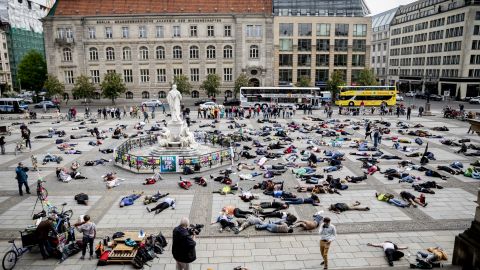 Extinction Rebellion climate change activists lie on the floor to symbolize a "mass die" at the Gendarmenmarkt square in Berlin on April 27, 2019.