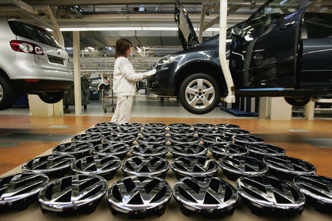 A worker stands by Volkswagen hood ornaments at the Golf production line at the Volkswagen factory in Wolfsburg, Germany.