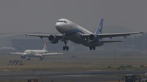 Jetliners take off from the Benito Juarez International Airport as smoke and pollution hangs Mexico City, Thursday, May 16, 2019.