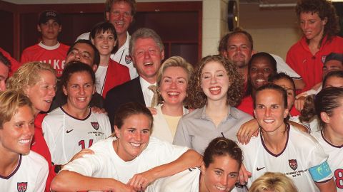 US President Bill Clinton (L), First Lady Hillary Clinton (C) and daughter Chelsea Clinton with members of the U.S. Women's soccer team in the locker room.