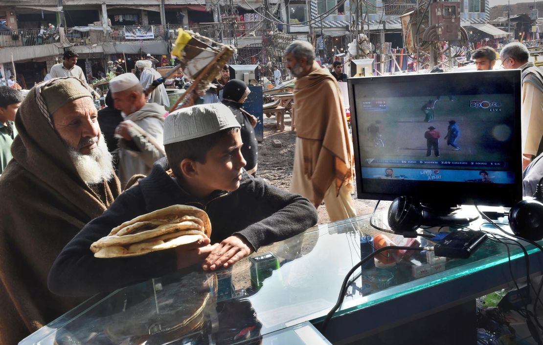 Afghan refugees watch the live broadcast of the Cricket World Cup match between Afghanistan and Bangladesh at a market in Peshawar in February 2015.