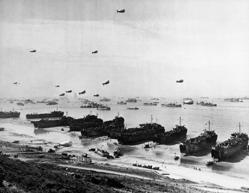 Landing craft and a fleet of protection vessels approach Omaha Beach.