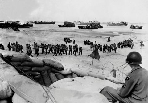 Allied soldiers arrive on a beach.