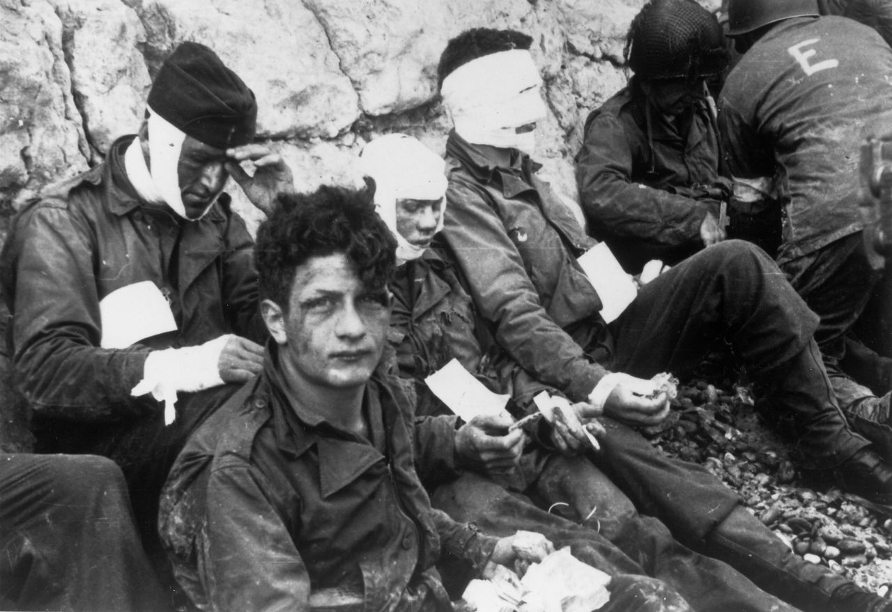 Injured American soldiers wait to be moved to a field hospital after storming Omaha Beach.