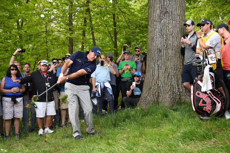 Phil Mickelson plays a shot from the rough on the third hole.
