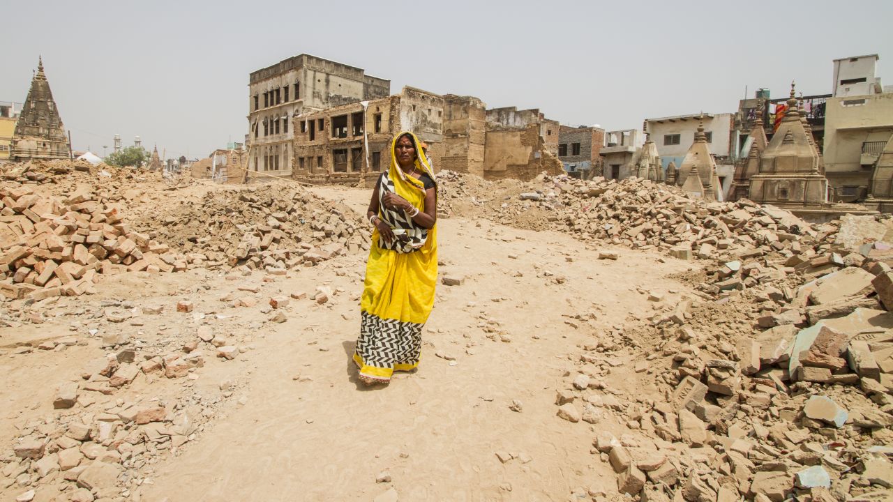 A woman walks through a demolition site, where buildings have been cleared to make way for the Kashi Vishwanath temple corridor in Varanasi.