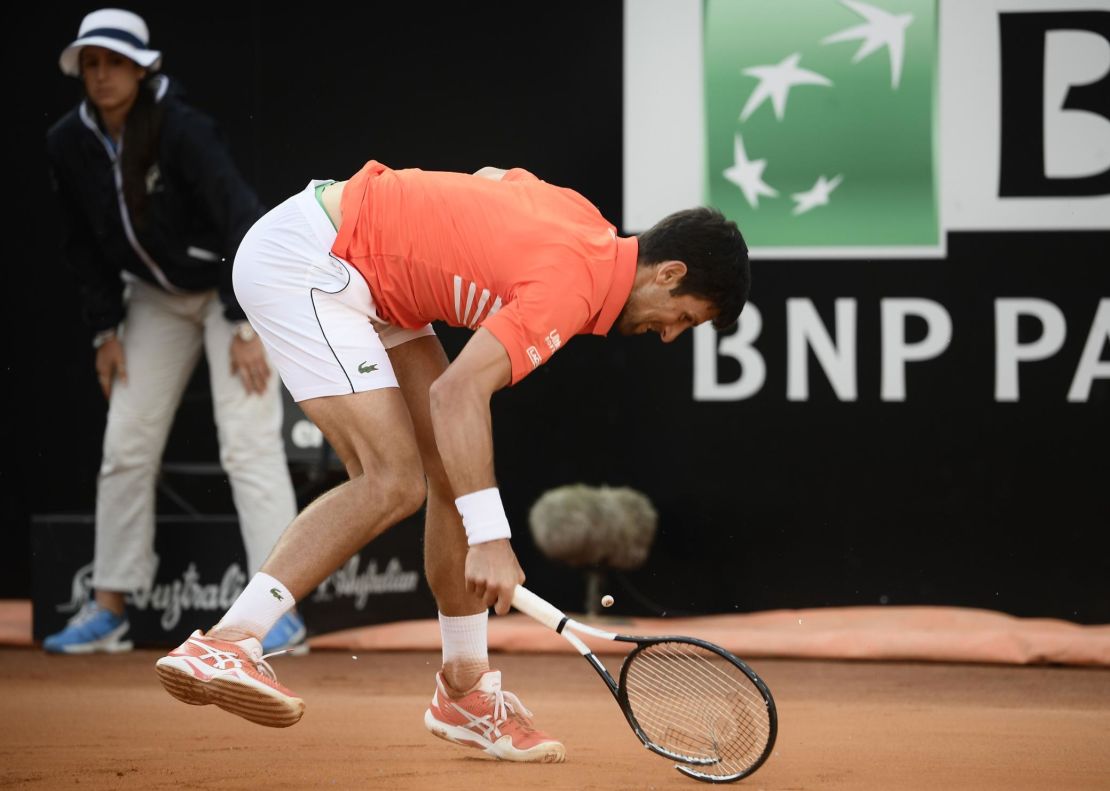 Novak Djokovic smashes his racquet after being broken.