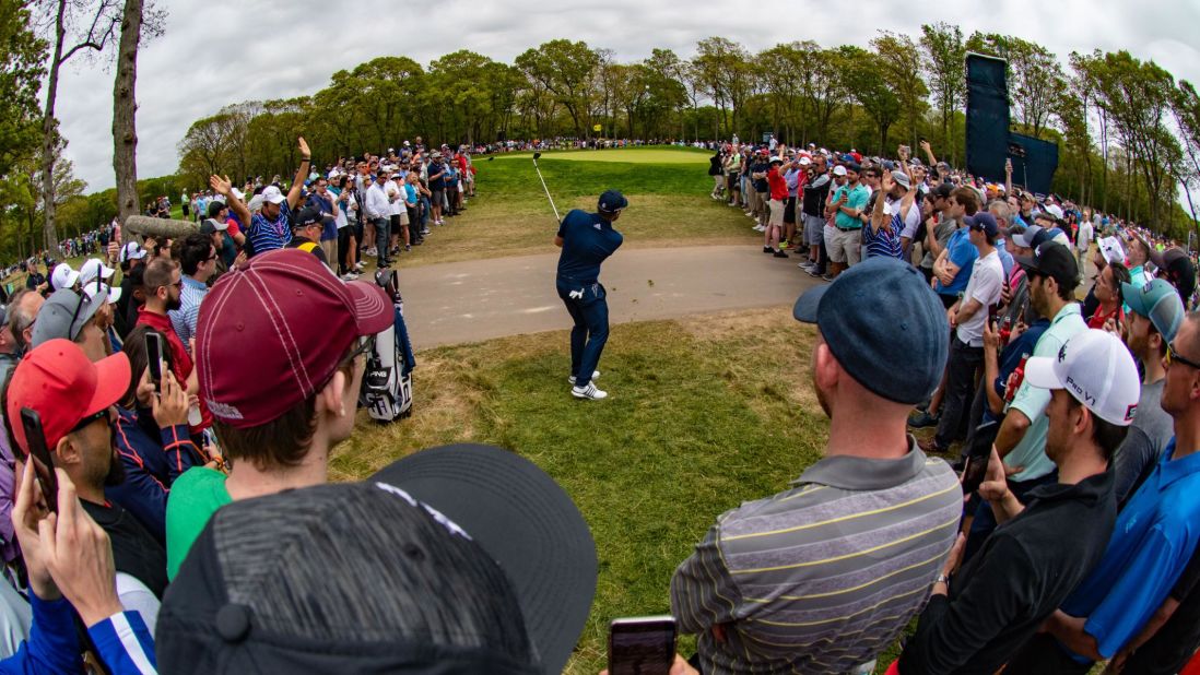 Tyrrell Hatton of England makes a shot out of the rough amidst the gallery on the ninth hole during the final round.