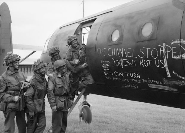 Airborne troops admire the graffiti chalked on the side of their glider as they prepare to fly out as part of the second drop on Normandy, on the night of June 6, 1944. 