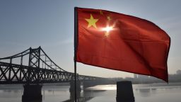 TOPSHOT - The Chinese flag flies on the Yalu River Broken Bridge, with the Sino-Korean Friendship Bridge, and the North Korean city of Sinuiju behind, in the border city of Dandong, in China's northeast Liaoning province on February 23, 2019. - North Korean leader Kim Jong Un's train is expected to cross the Friendship Bridge on a journey across China before Kim's summit meeting with US President Donald Trump in Vietnam on February 27. (Photo by GREG BAKER / AFP)        (Photo credit should read GREG BAKER/AFP/Getty Images)