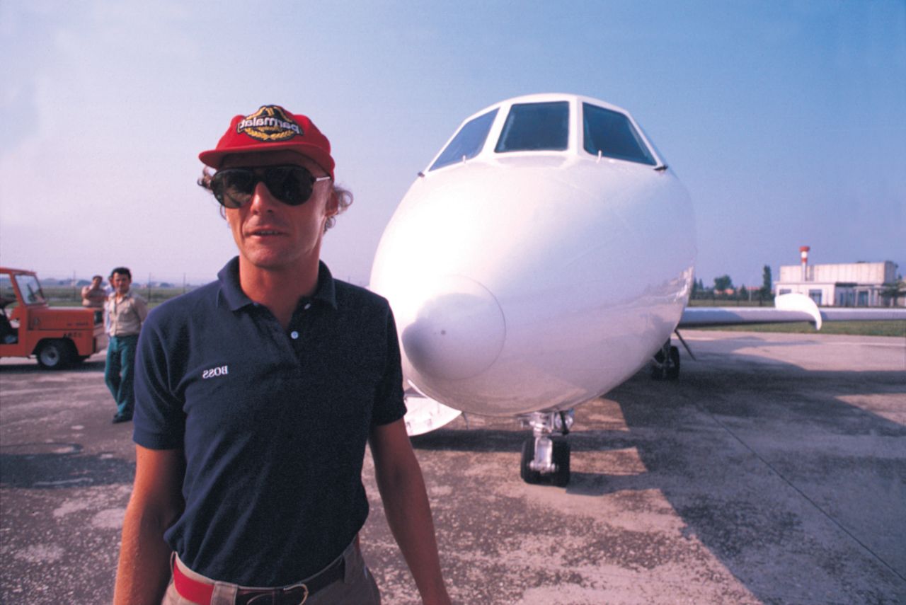 Lauda poses beside an airplane.
