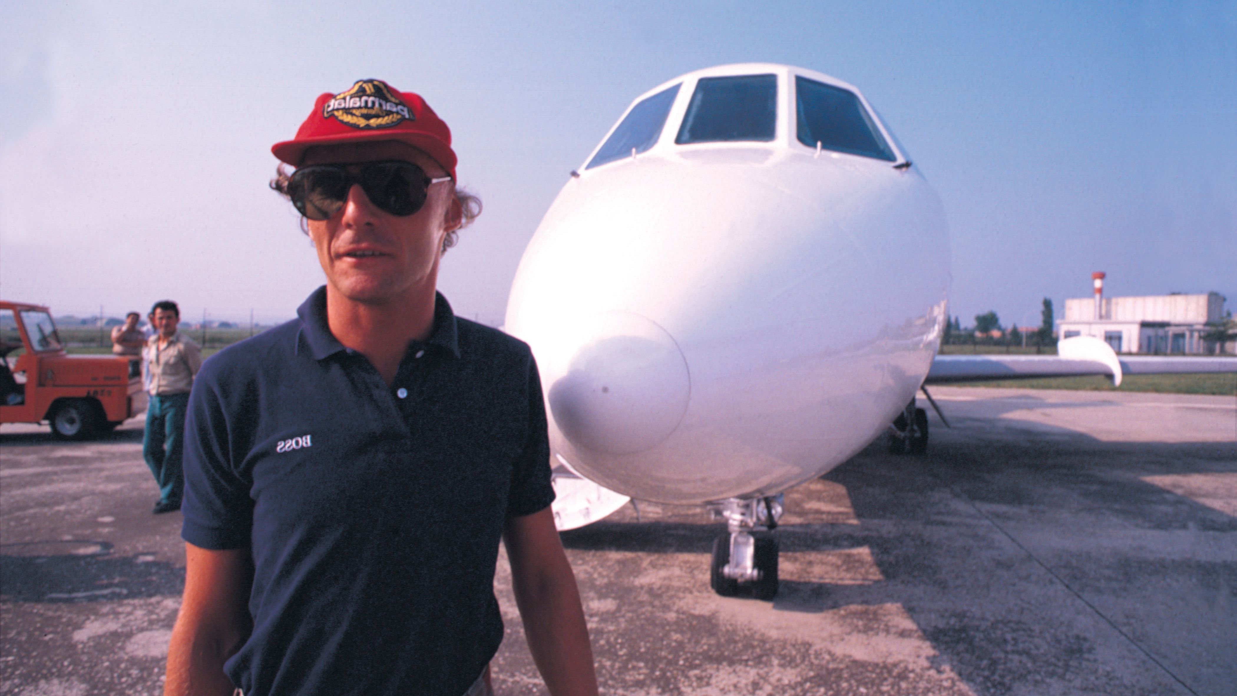 Lauda poses beside an airplane.