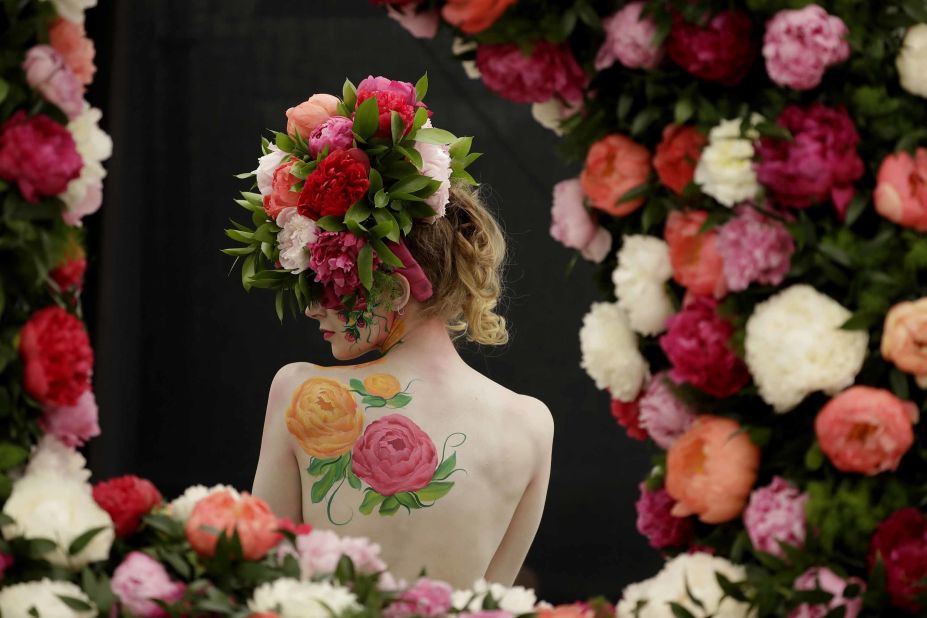 A model poses with a peony design in body paint and headpiece at the flower show's press viewing on Monday.