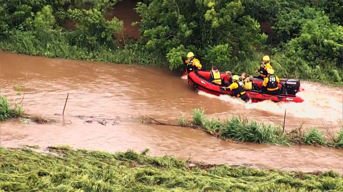 Firefighters guide a boat carrying four people against fast-moving floodwaters near El Reno, Oklahoma, on Tuesday morning.