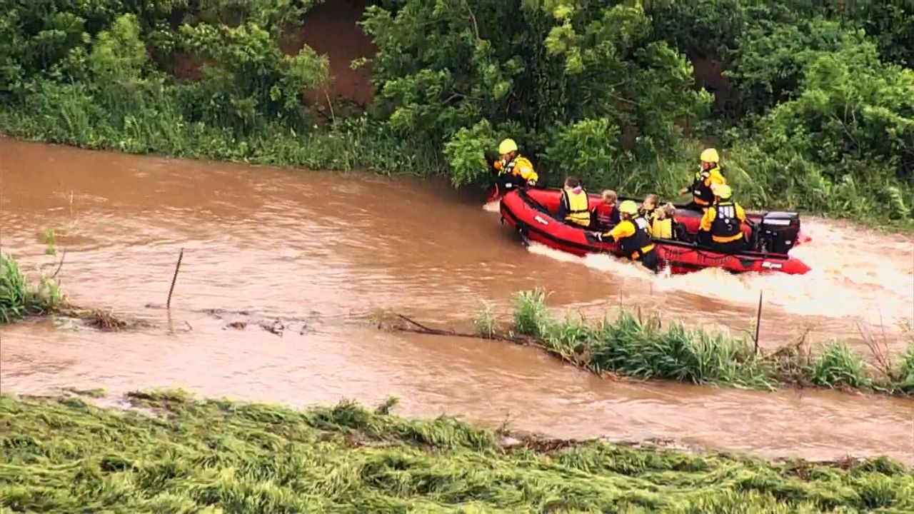 Firefighters guide a boat carrying four people against fast-moving floodwaters near El Reno, Oklahoma, on Tuesday morning.