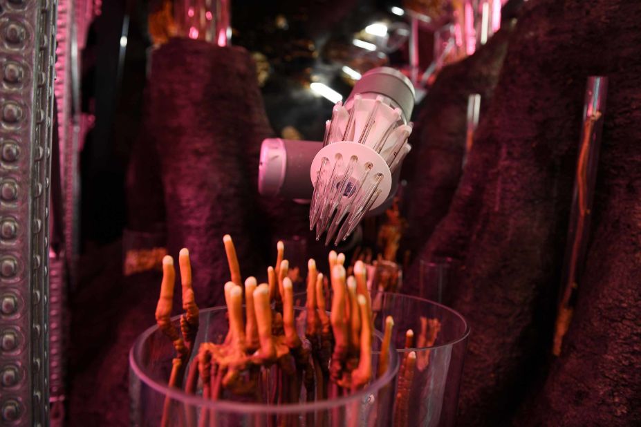 A robotic arm stimulates the spread of spores as Chinese mushrooms grow under artificial light in the "IKEA: Gardening will save the World" display, designed by Tom Dixon.