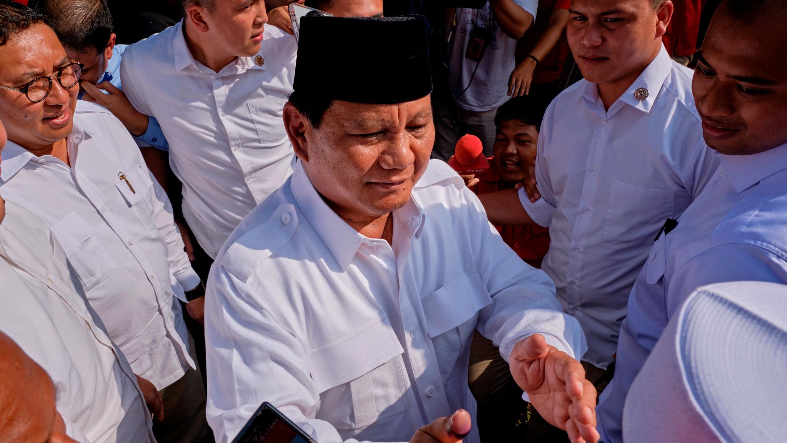 Indonesian Presidential candidate Prabowo Subianto shakes hands with voters after casting his vote at a polling station on April 17, 2019 in Babakan Madang, Indonesia. 