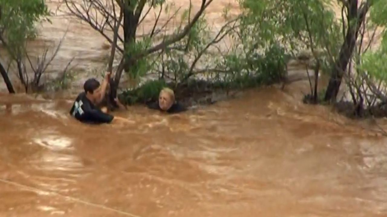 A man helps a woman who was found clinging to a tree Tuesday morning near El Reno, Oklahoma.