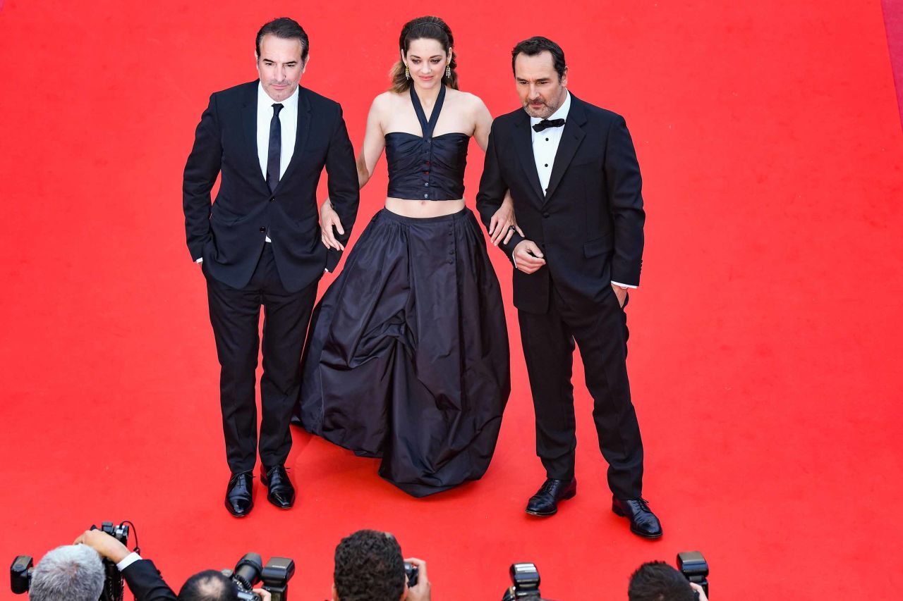 Marion Cotillard (flanked by French actors Jean Dujardin and Gilles Lellouche) wears a halterneck crop top and matching floor-length skirt. 