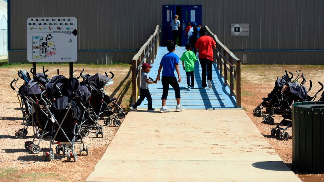 In this August 2018 photo provided by US Immigration and Customs Enforcement, immigrants enter a building at the South Texas Family Residential Center in Dilley, Texas.