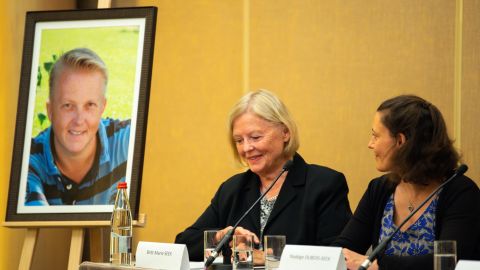 Nadege Dubois-Seex (right) at a Paris press conference alongside a portrait of her late husband.