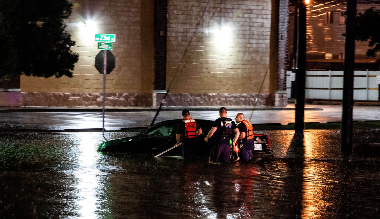 People push a car after it stalled in rising floodwaters in Oklahoma City on May 20. 