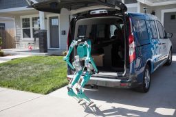 Ford's robot climbs out of a vehicle to make a delivery.