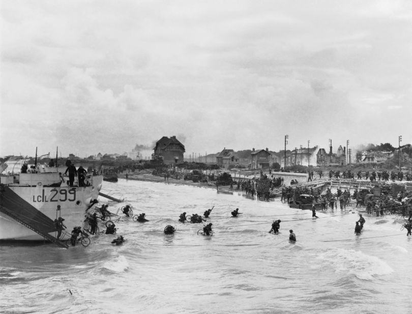 Troops of 9th Canadian Infantry Brigade disembarking with bicycles onto 'Nan White' beach, Juno sector, at Bernieres-sur-Mer shortly before midday on June 6.