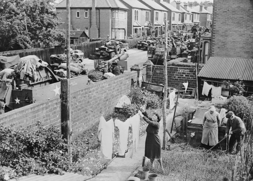The Bagg family hang out their washing in Hill Lane, Southampton on June 5, 1944. Behind them, an American field howitzer unit waits before moving to the docks to embark for Normandy.