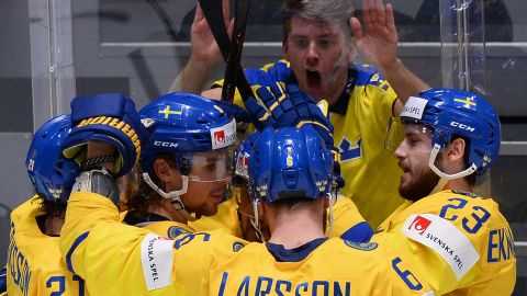 Sweden's players celebrate next to a fan during a 5-4 victory over Latvia.
