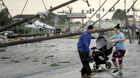 Jessica Rodgers and Ray Arellana carry a stroller over downed power lines  Thursday in Jefferson City.