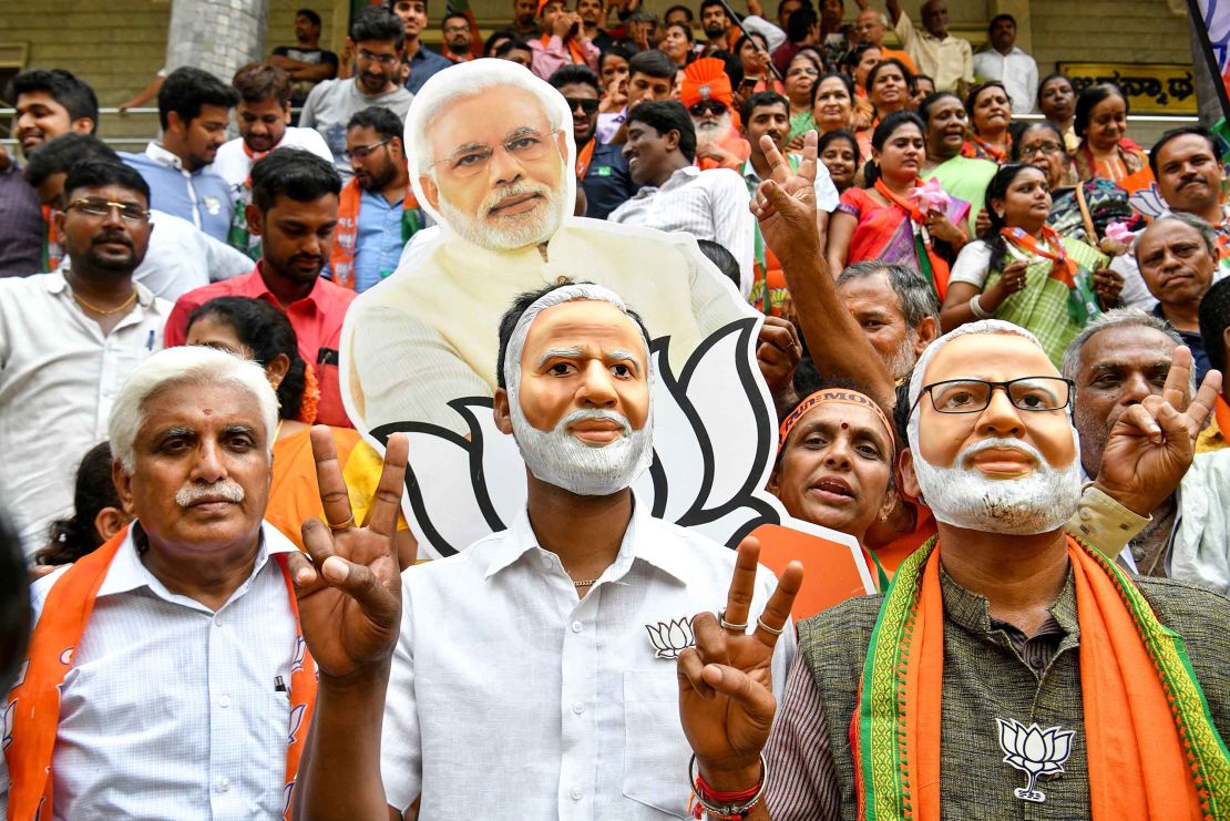 Supporters wear masks of Indian Prime Minister Narendra Modi and flash victory signs as they celebrate on the vote results day for India's general election on May 23, 2019.