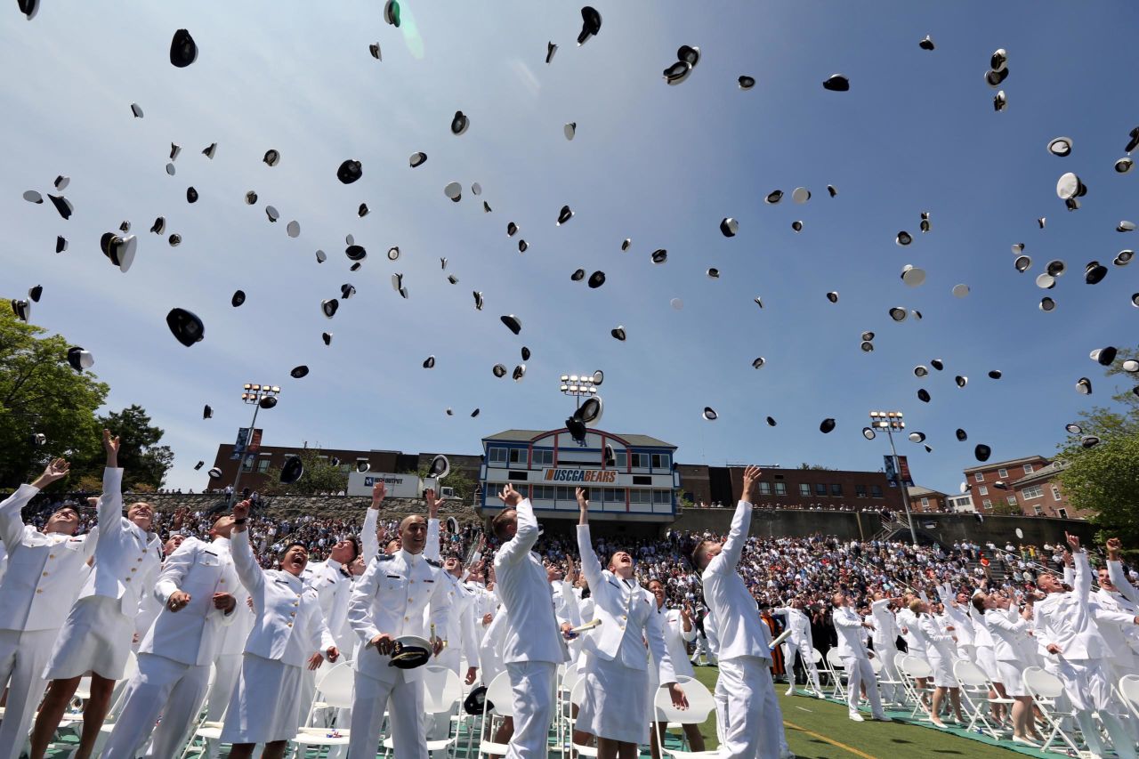 Members of the United States Coast Guard Academy throw their hats in the air during a graduation ceremony in New London, Connecticut, on Wednesday, May 22.