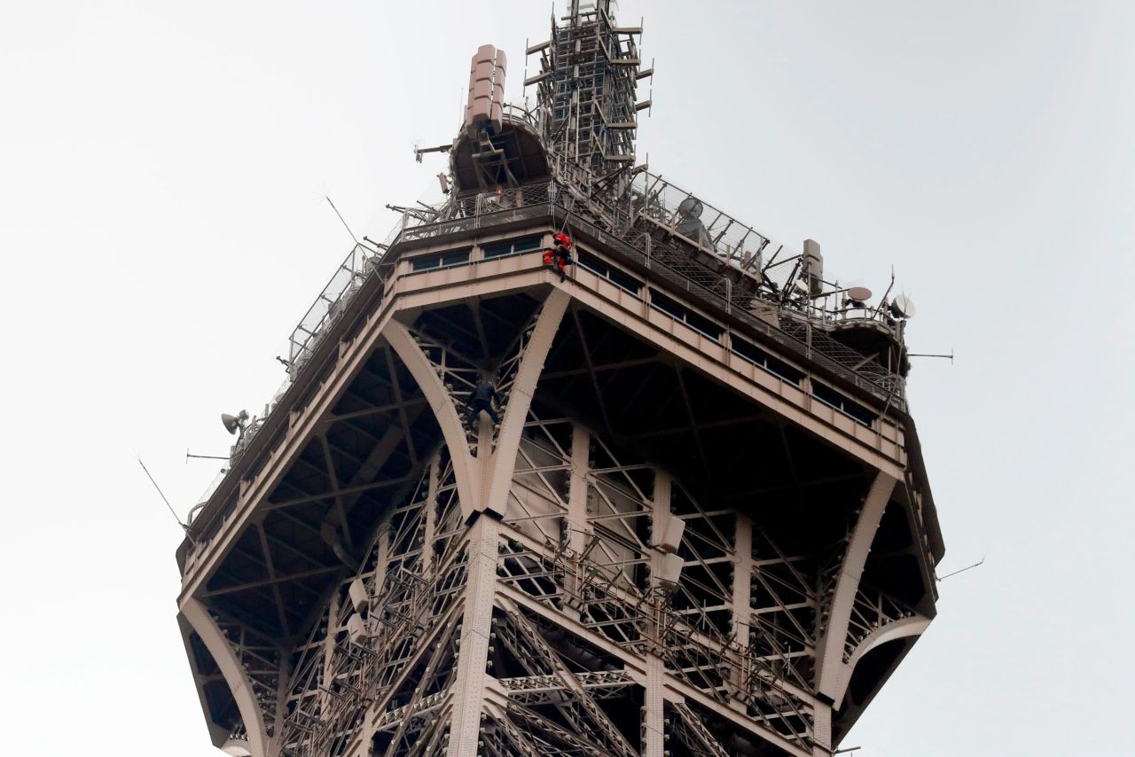 A rescue worker (in red) hangs from the Eiffel Tower in Paris as a man below him (in black) <a href="https://www.cnn.com/2019/05/20/europe/eiffel-tower-closed-man-climbing-intl/index.html" target="_blank">climbed the famous structure</a> on Monday, May 20.