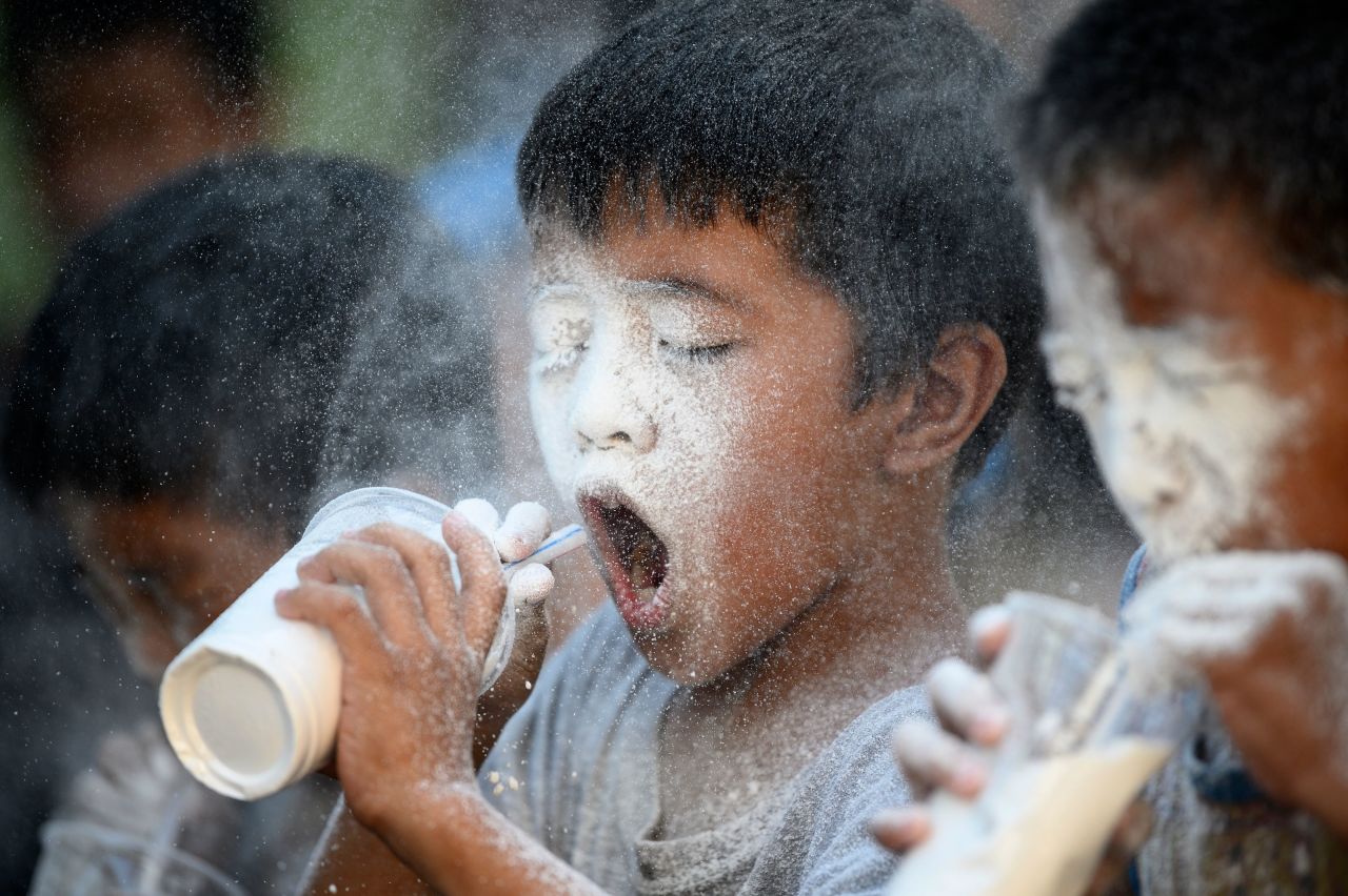 Boys in Manila, Philippines, blow through straws to try to empty cups filled with flour on Sunday, May 19. The game was part of feast-day festivities for St. Rita of Cascia.