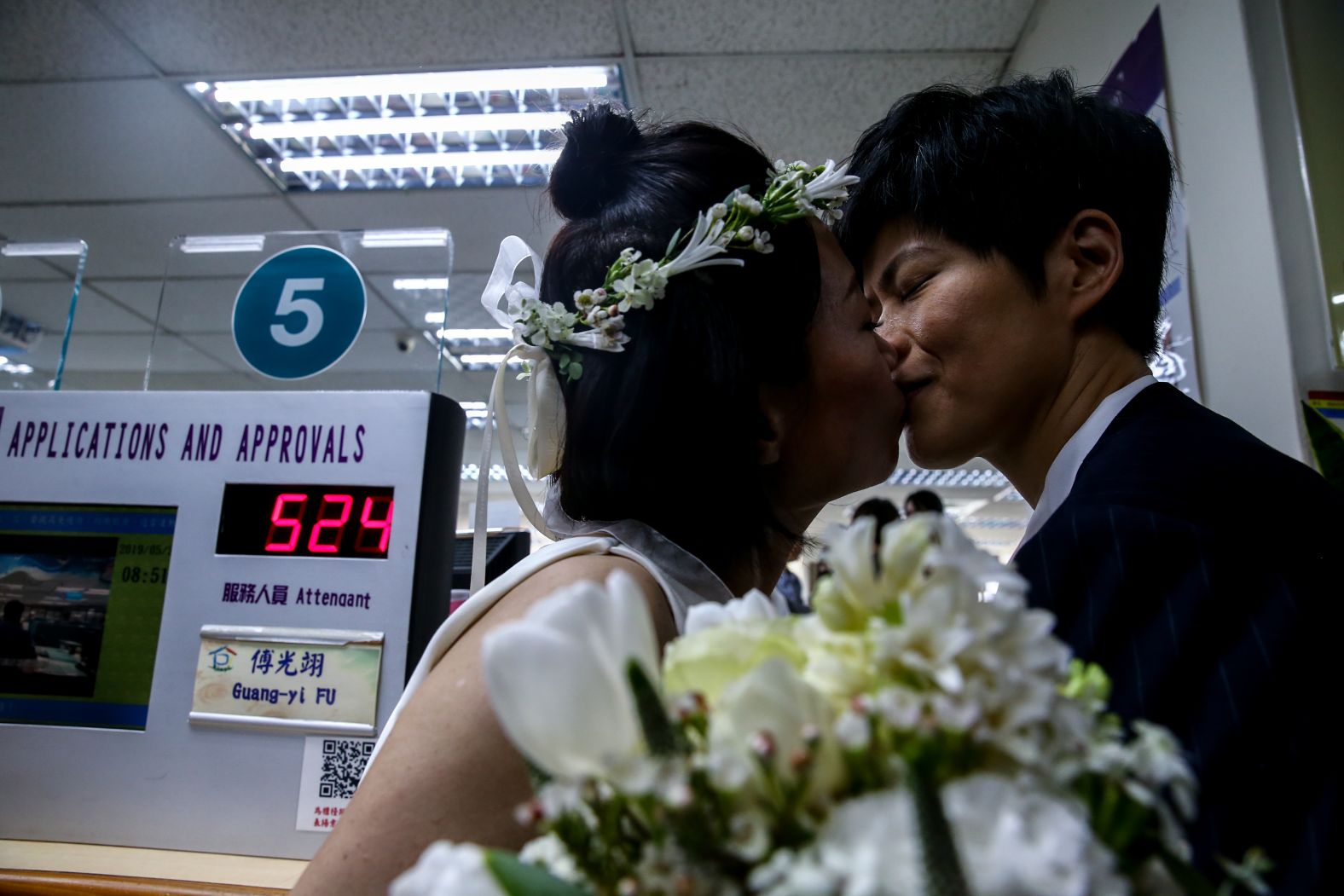 Xue Chen, left, and Antonia Chen, right, kiss after registering their marital status on Friday.