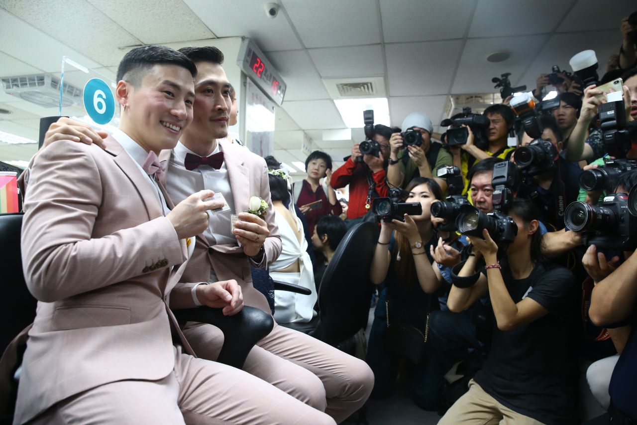 Newly married couple Marc Yuan, right, and Shane Lin, left, celebrate after receiving new identification cards on Friday.