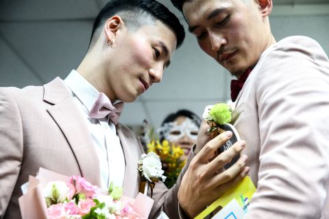 Gay couple Marc Yuan, left, and Shane Lin, right, come to registration office on Friday to update their marital status and receive new identification cards.