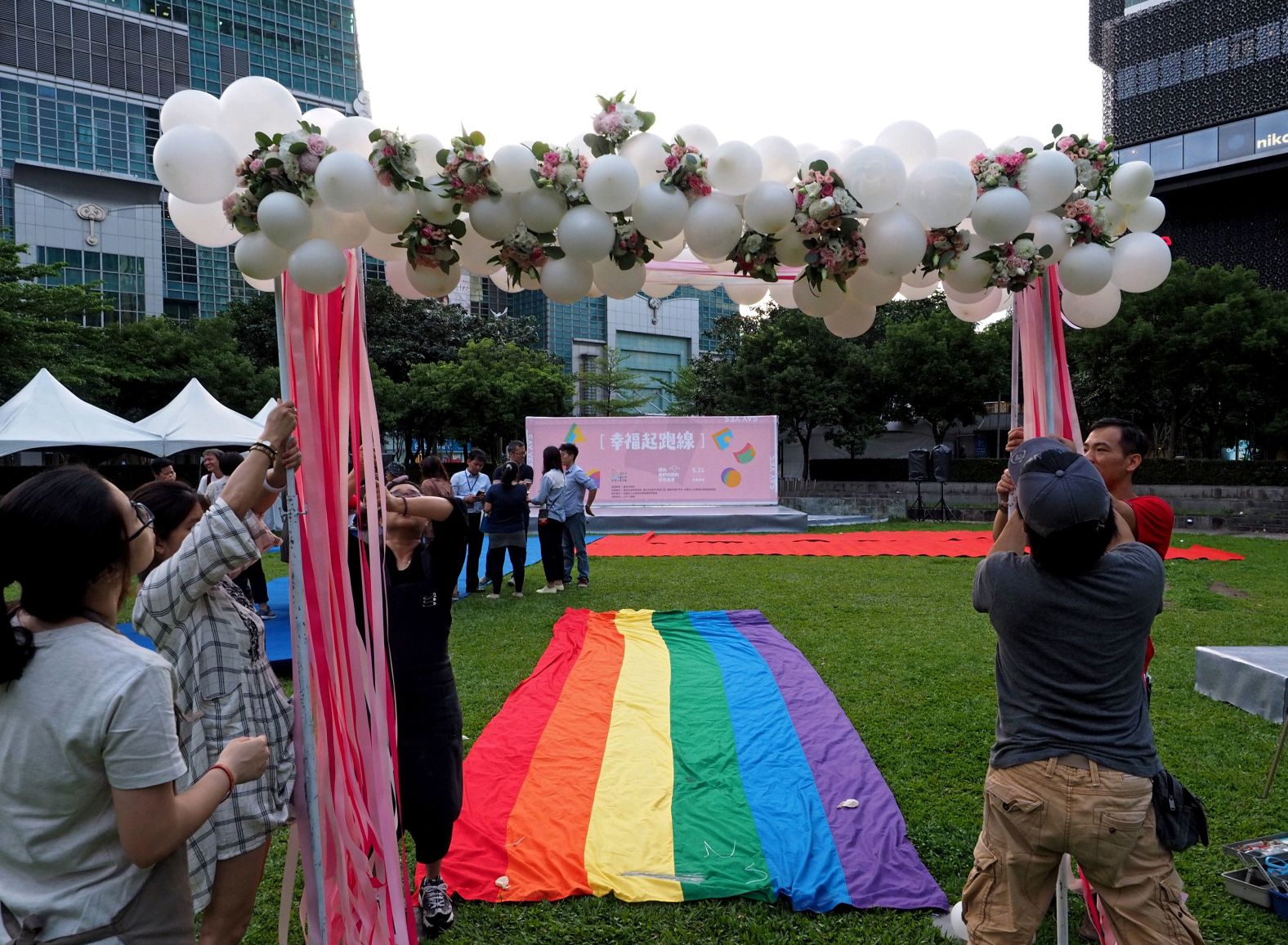 LGBT activists put up an archway for gay couples to walk a rainbow flag carpet to a stage near the Taipei 101 skyscraper.