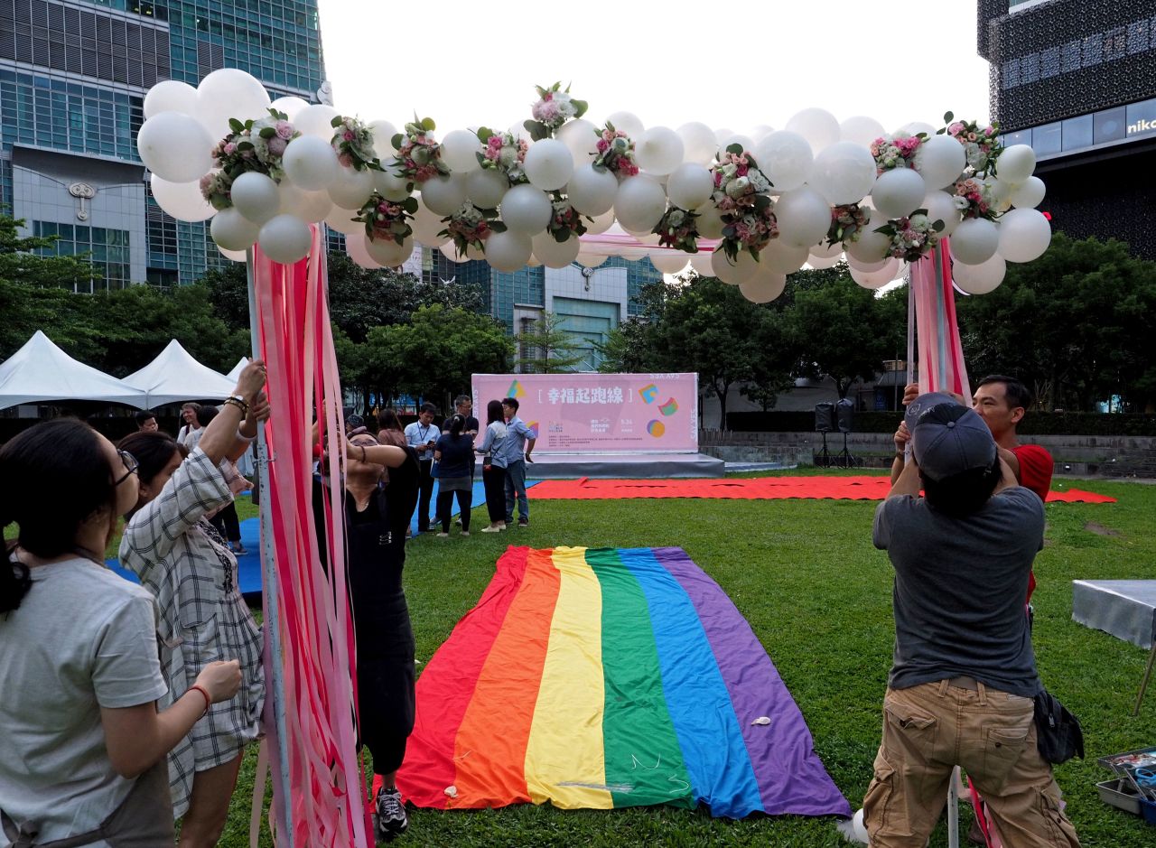 LGBT activists put up an archway for gay couples to walk a rainbow flag carpet to a stage near the Taipei 101 skyscraper.